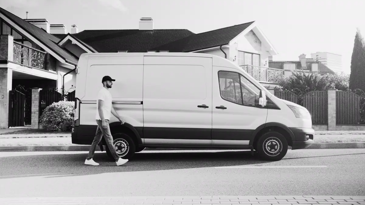 Transporter vor einem Wohnhaus, Schwarzweißaufnahme